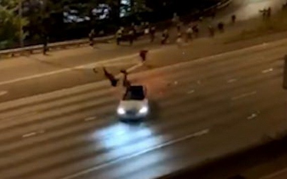 錄影顯示，一輛白色汽車高速向人群駛來，人們慌忙躲避，但兩人遭汽車撞飛。（圖源：視頻截圖）