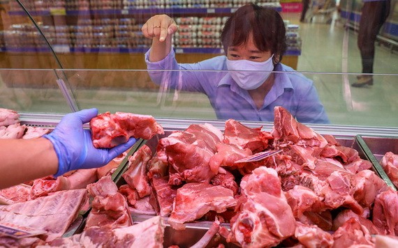 消費者在超市裡的肉攤選購鮮豬肉。（圖源：田升）