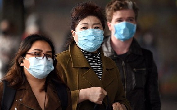 圖為墨爾本居民戴口罩出行。（圖源：AFP）