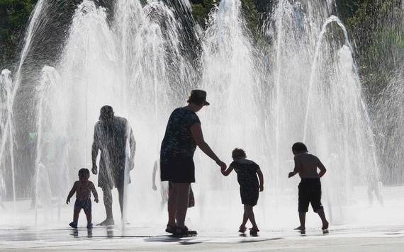 在法國東部城市科爾馬，一家大小在地面噴泉上淋水消熱。（圖源：AFP）