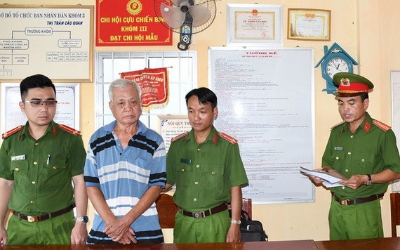涉案嫌犯陳金利（左二）站立著聽取執法警員宣讀拘捕令。
