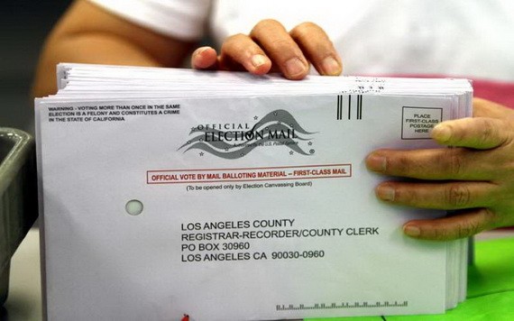 一名職員在辦公室對郵寄選票進行分類。（圖源：洛杉磯時報）