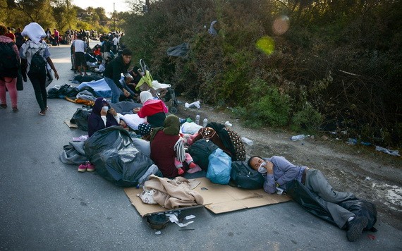 在希臘萊斯沃斯島，發生火災後逃離莫里亞難民營的難民和非法移民在路邊休息。（圖源：新華社）