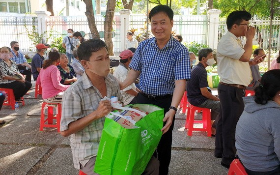 第五郡越南祖國陣線委員會主席黎晉才送禮物給貧困戶。