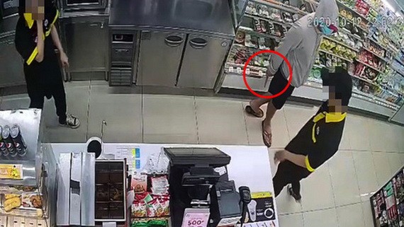 一名戴著口罩的男子手持刀具威脅便利店裡的2名員工交出錢來。（圖源：監控視頻截圖）