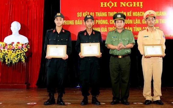 安江省公安廳廳長丁文處大校（右二）向3 名英勇營救遇險船員的水路警察頒贈獎狀。