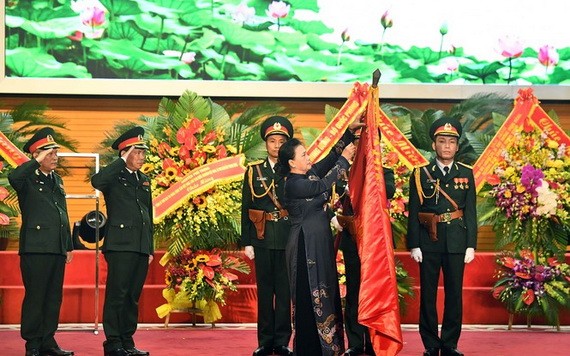 國會主席阮氏金銀為《人民軍隊報》傳統旗幟上佩掛三等獨立勳章。（圖源：前鋒報）