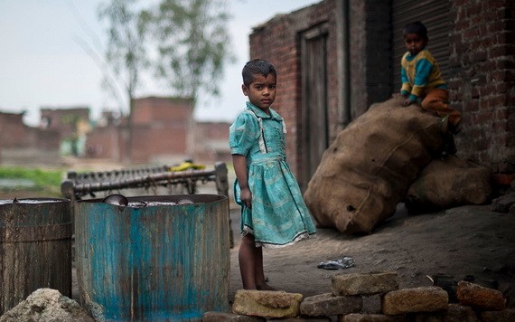 印度北方邦的貧民窟，兒童在一家金屬拋光工廠外玩耍。（圖源：聯合國）