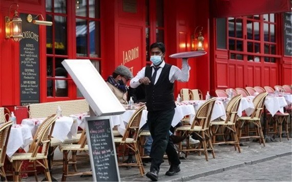 巴黎蒙馬特高地小丘廣場服務員在一家餐館外忙碌。（圖源：新華社）