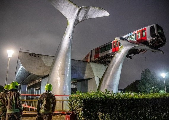 荷蘭一列火車在高空軌道行駛時，突然衝出軌道盡頭，險些墜落，萬幸被一座鯨魚雕塑“接住”，懸掛在空中，未造成人員傷亡。（圖源：互聯網）