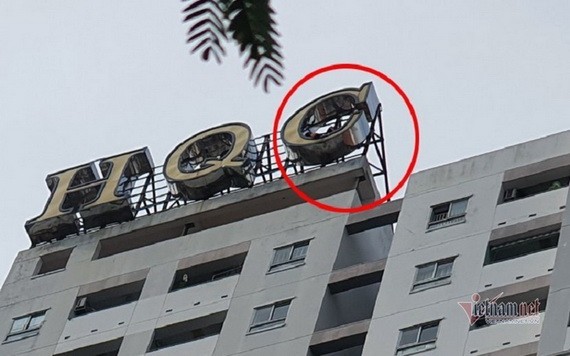 一名青年爬上公寓頂層，躺在招牌位置，有意跳樓自盡。（圖源：VNN）