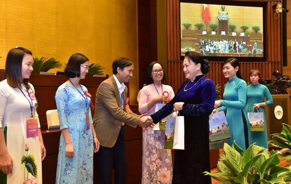 國會主席阮氏金銀向模範教師親切問候並贈送禮物。（圖源：林顯）