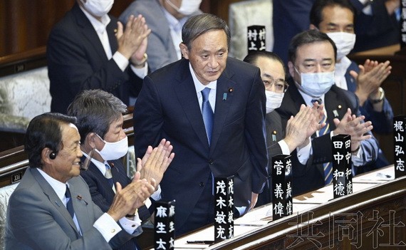 日本首相菅義偉向全體與會者鞠躬行禮，以示敬意。（圖源：共同社）