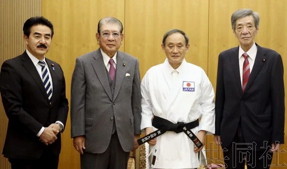 日本首相菅義偉（右二）被授予空手道九段位。（圖源：共同社）