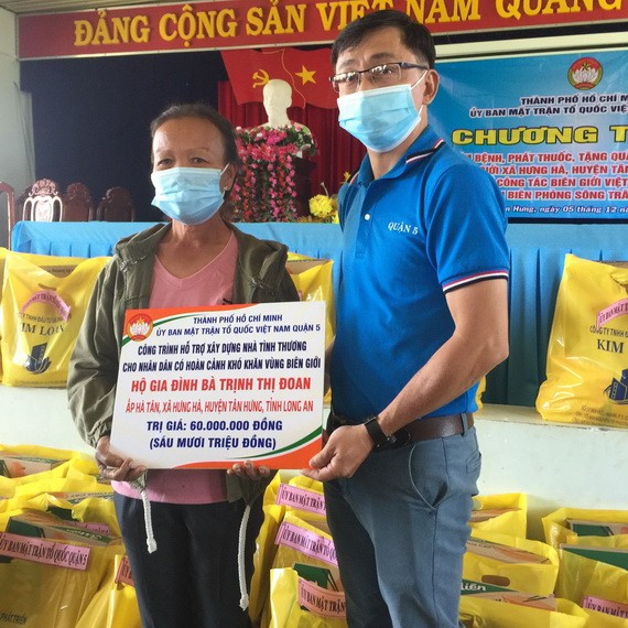第五郡越南祖國陣線委員會副主席陳南德向貧戶贈送建溫情屋經費。
