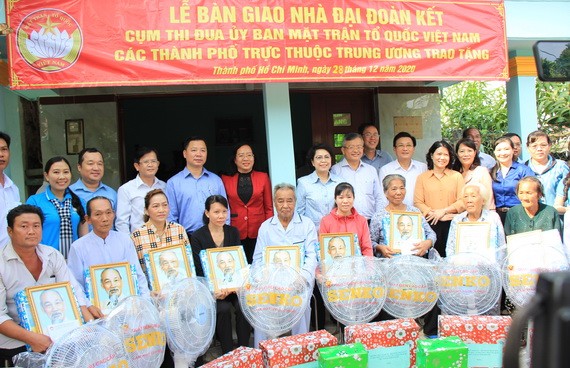 市越南祖國陣線委員會領導向貧困戶贈送胡伯伯肖像及禮物。