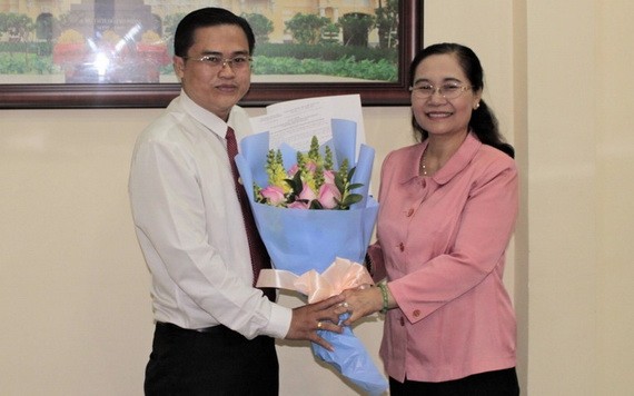 高清平同志（左）從市人民議會主席阮氏麗手中接過人事委任《決定》和祝賀鮮花。（圖源：元宇）