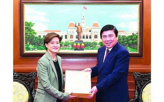 市人委會主席阮成鋒（右）向新加坡駐越南特命全權大使凱瑟琳‧王贈送紀念品。（圖源：越勇）