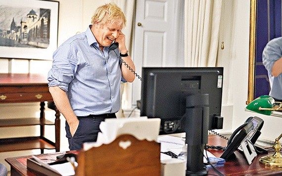 英國首相約翰遜23日和美國總統拜登通電話時笑逐顏開。（圖源：路透社）