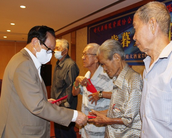 張豐裕先生（左一）同貧困老人分享自己八十大壽的喜悅。