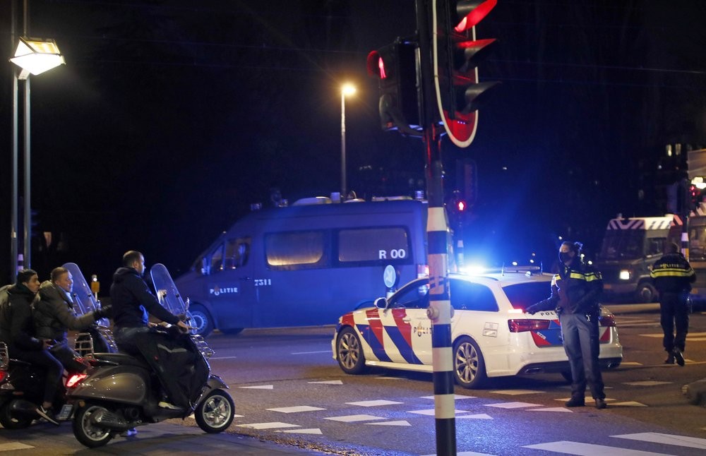 當地時間26日，荷蘭阿姆斯特丹，一名警官在路障上向三名機車騎士勸說。（圖源：AP）