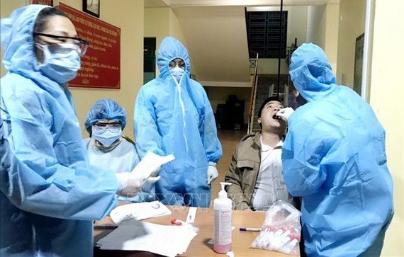 防疫工作人員向新冠肺炎疑似患者進行深喉拭子取樣測試。（圖源：越通社）