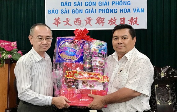 范興編委(左)接受丁文森贈送的新年禮物。