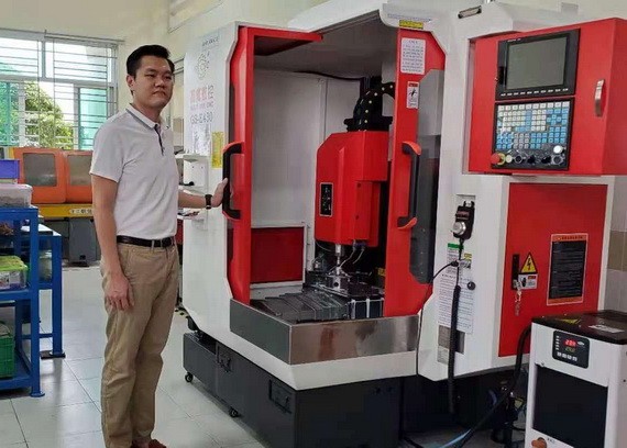 紅心企業經理劉成發攝於新添購的CNC機器。