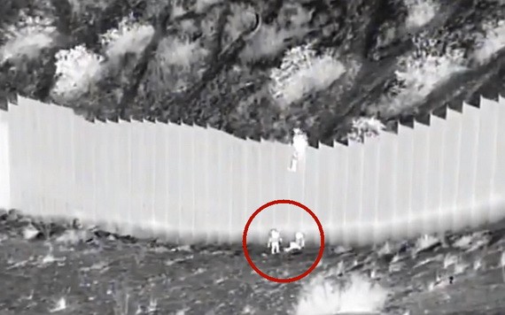 兩名女童被扔過邊境牆（視頻截圖）。