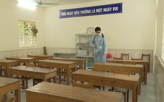 防疫工作人員在為教室課桌椅及講台進行消毒。（圖源：陶芳）