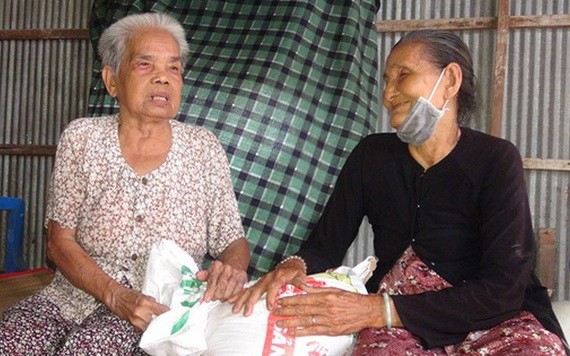 五婆（右）帶著善良的笑容向泰婆贈送大米。