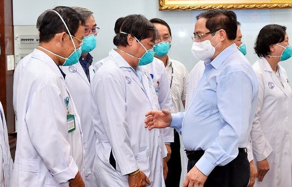 2021年5月13日，政府總理范明政（前右）向市大水鑊醫院的守崗醫護隊伍致以誠摯的問候。（圖源：VGP）