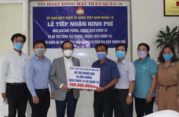 張豐裕先生(左三)代表萬盛發集團向第十郡越南祖國陣線委員會移交善款。