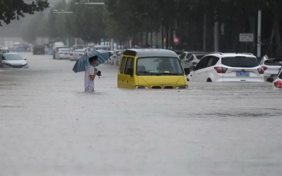 中國河南鄭州強降雨，行人20日涉水通過積水路段。（圖源：互聯網）
