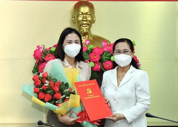 范氏清賢同志（左）從市人民議會主席阮氏麗手中接過委任《決定》和祝賀鮮花。（圖源：越勇）