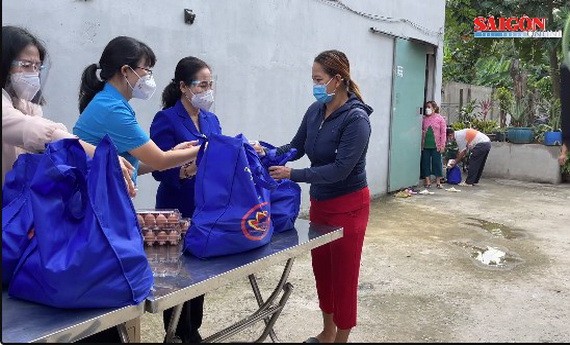 市人民議會主席阮氏麗（右二）向古芝縣受新冠肺炎疫情影響的工人與勞動者贈送禮物。（圖源：視頻截圖）