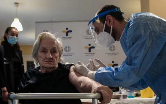 希臘首都雅典的一名大娘接受新冠疫苗注射。（圖源：互聯網）