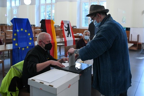 柏林投票站一名選民（右）參加聯邦議院選舉投票。（圖源：新華社）