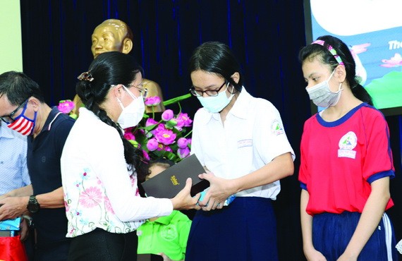 市祖國陣線委員會副主席潘嬌清香向占婆族貧困學生贈送平面電腦設備。