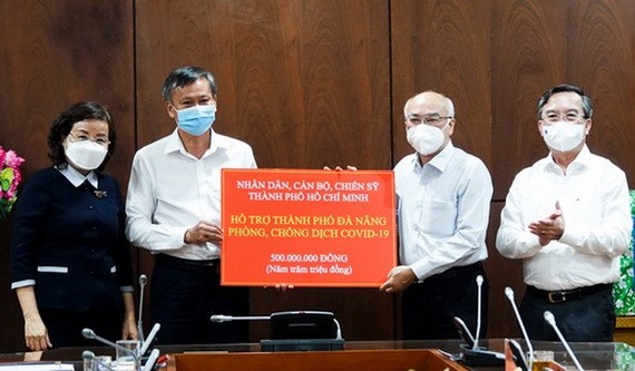 市委宣教處主任潘阮如奎（右二）代表市領導與人民向峴港市捐助5億元、1箱檢測試劑盒與1箱防護服。（圖源：春瓊）