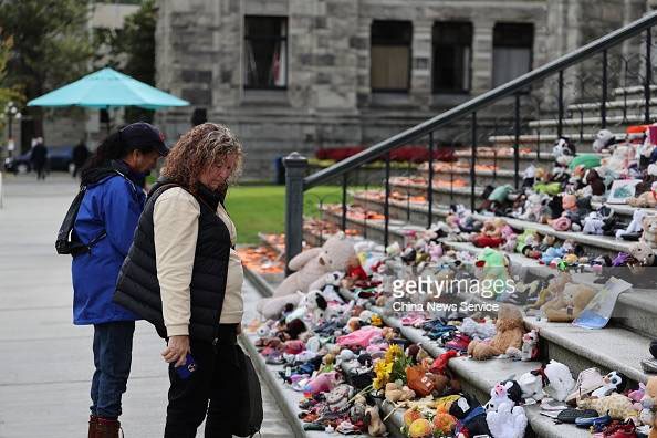 加拿大不列顛哥倫比亞省首府維多利亞市省議會大樓前，擺放著大量兒童玩偶及童鞋，以哀悼在過去的原住民寄宿學校中死亡的兒童。（圖源：Getty Images）