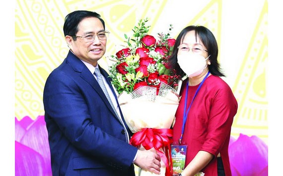 政府總理范明政向模範教師代表送花祝賀。（圖源：越通社）
