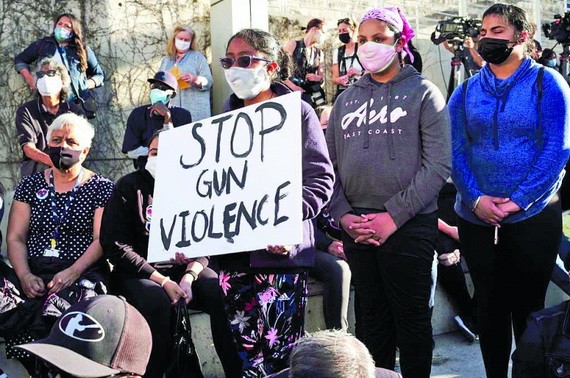 在美國街頭上遊行隊伍中的一名婦女雙手捧著反對槍支暴力的標語。（圖：互聯網）