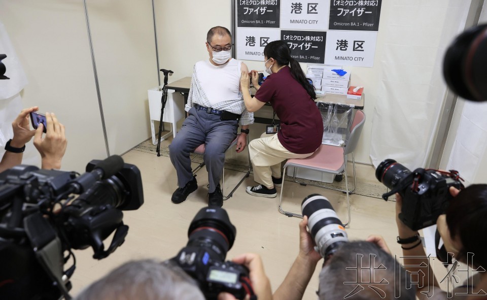 圖為 9月20日上午，一名男性（左）在東京都港區接種應對新冠病毒奧密克戎變異株的疫苗。（圖：共同社）