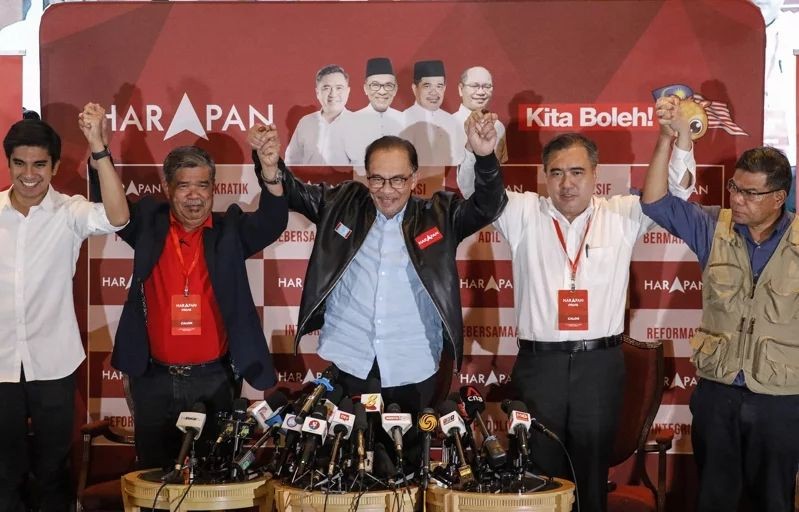 馬來西亞在野黨希望聯盟在這次大選贏得最多席次，領導人安瓦爾（中）與該黨高層廿日在吉隆坡總部振臂慶功。（圖：歐新社）
