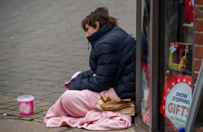 一名無家可歸者坐在人行道上。（圖：互聯網）