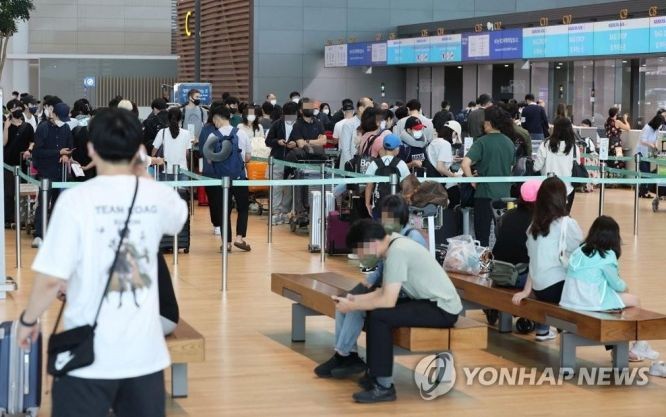 2022年9月14日，在仁川国际机场第二航站楼，旅客们正在排队等待办理登机手续。随着自海外入境韩国前核酸检测规定的废除，出国客流大增。 （图：韩联社）