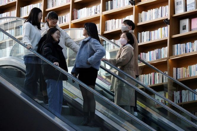 1月30日，韩国解除室内戴口罩令的第一天，首尔一家购物中心内的购物者中，有人选择不戴口罩，有人则继续戴口罩。（图：路透社）
