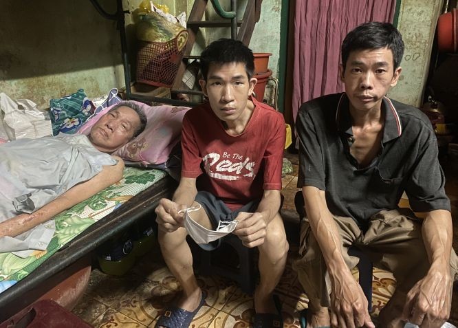 （左起）卧床的朱锦明与两个儿子朱镇鸿和朱镇荣。