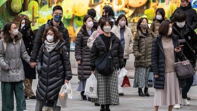 当地时间2023年1月27日，日本东京，人们戴着口罩等待过马路。（图：视觉中国）